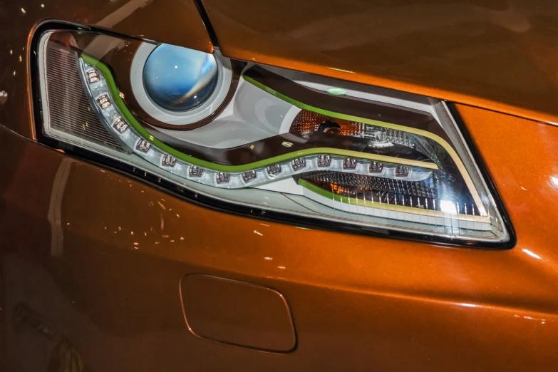 a close up of a headlight on a car, a digital rendering, by Thomas Häfner, reddit, orange and green power, photo realistic”, interior light, hybrid