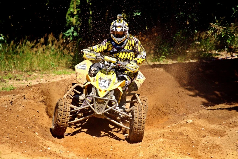 a person riding a dirt bike on a dirt track, a photo, flickr, silver and yellow color scheme, buggy, yellow helmet, rich evans