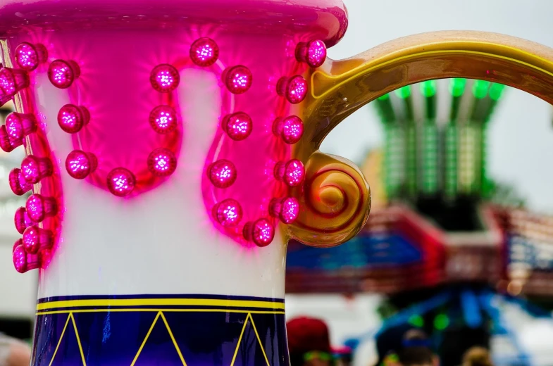 a pink and blue vase sitting on top of a table, a photo, by Etienne Delessert, flickr, maximalism, fairground rides, purple liquid in cup glowing, tomorrowland, detail shots