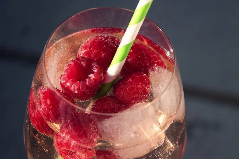 a glass of water with raspberries in it, pexels, romanticism, with a straw, shiny and sparkling, rose, close establishing shot