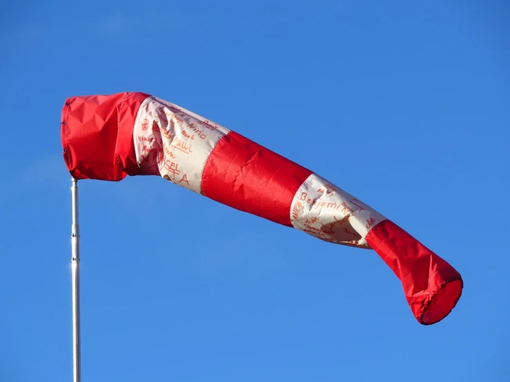 a red and white flag blowing in the wind, inspired by Jan Rustem, under repairs, north pole, vandalism, horn