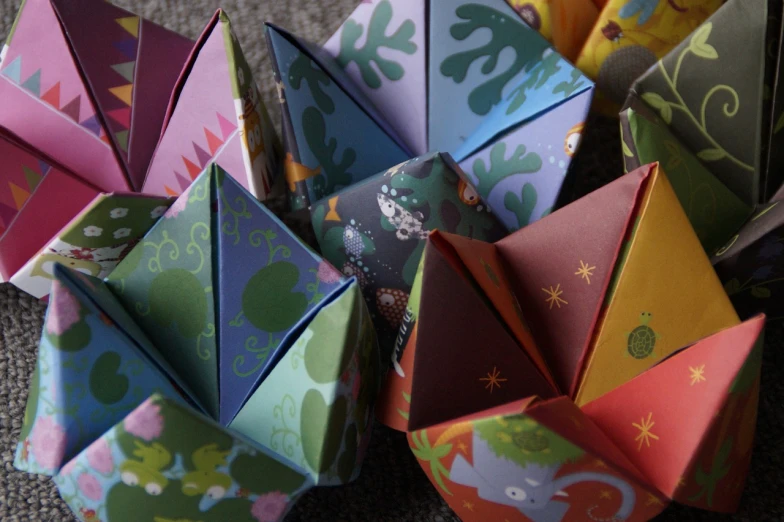a close up of a bunch of origami paper flowers, a screenshot, by Aileen Eagleton, flickr, process art, dragon eggs, childrens toy, zodiac, forest theme