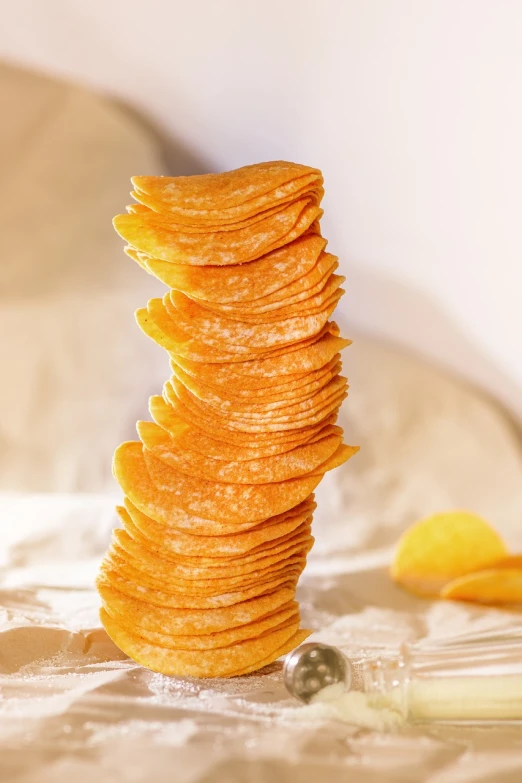 a stack of potato chips sitting on top of a bed, pexels, photorealism, 🐎🍑, show from below, parchment paper, cheddar