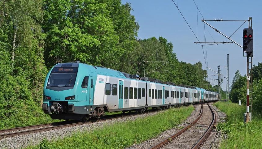 a large long train on a steel track, by Karl Völker, shutterstock, sea - green and white clothes, detmold charles maurice, with teal clothes, accompanying hybrid