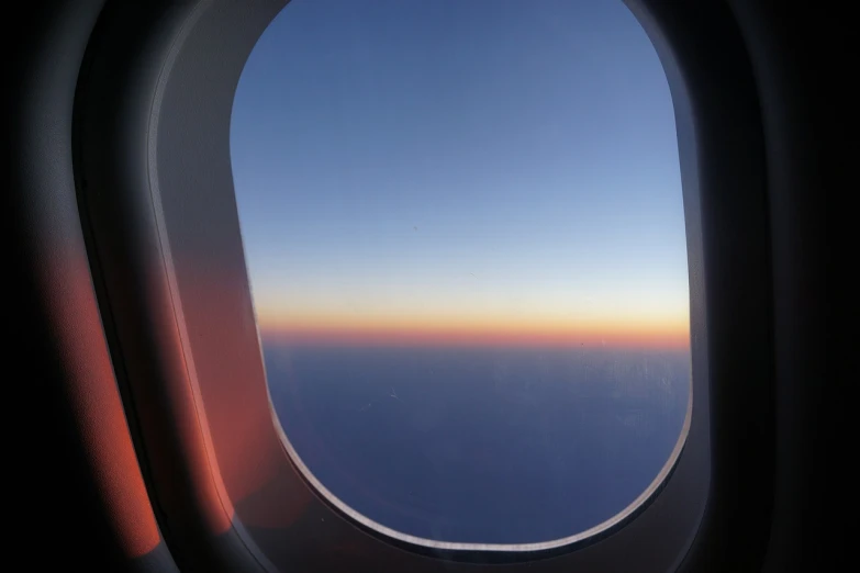 a view of the sky from an airplane window, a picture, by Erwin Bowien, hurufiyya, blue and orange rim lights, faint sunrise, the window is open, smooth gradation