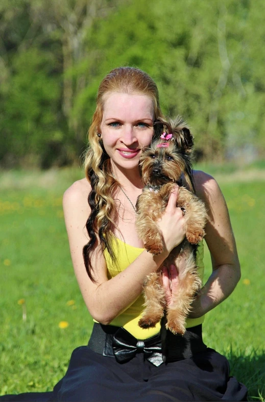a woman sitting in a field holding a small dog, a portrait, by Zofia Stryjenska, pixabay, holding her yorkshire terrier, hot petite teen girl, with very long blonde hair, with wart