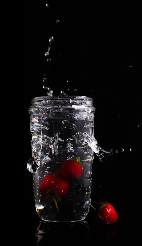strawberries are falling into a glass of water, by Ivan Grohar, glass jar, 8 0 mm photo, black-water-background, photorealism. trending on flickr