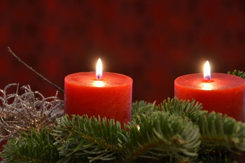 a couple of red candles sitting on top of a table, by Stefan Gierowski, evergreen branches, 4 k detail, wikimedia, version 3