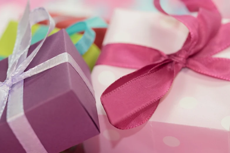 a couple of gift boxes sitting next to each other, by Rhea Carmi, pixabay, happening, pink and purple, close up shot from the side, ribbon, a wide shot