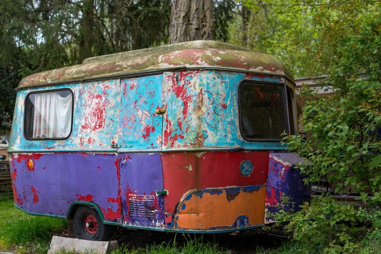 an old bus that is sitting in the grass, by Richard Carline, graffiti, full of colour 8-w 1024, caravan, hidden in the forest, chipped paint