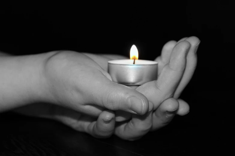 a person holding a lit candle in their hands, a black and white photo, closeup photo, portlet photo, high details photo