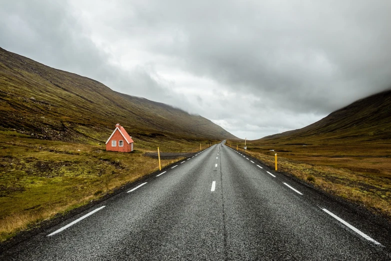 a red house sitting on the side of a road, by Hallsteinn Sigurðsson, pexels, realism, lost highway, orange roof, on a cloudy day, inside an epic