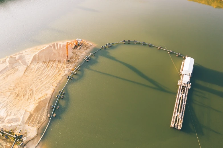 an aerial view of a bridge over a body of water, by Werner Gutzeit, gold pipelines, sand banks, panorama, crane