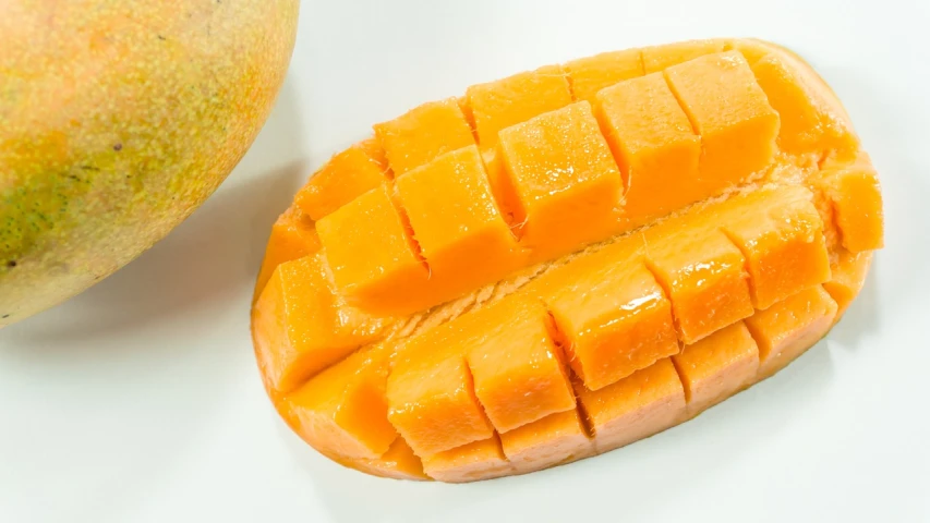 a mango cut in half on a white surface, by Emanuel Witz, pexels, hurufiyya, 😭 🤮 💕 🎀, chinese, platinum, rectangular