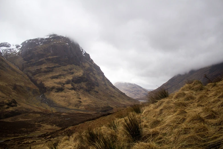 a view of a valley with a mountain in the background, a photo, by Alexander Scott, flickr, scottish style, empty remote wilderness, snow flurries, traverse
