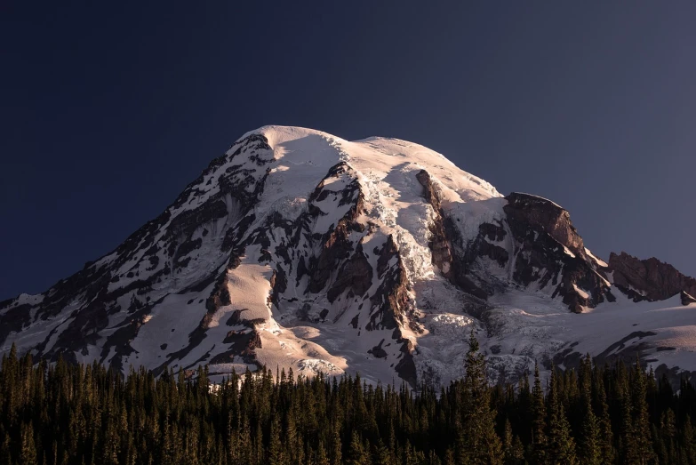 a snow covered mountain with pine trees in the foreground, a portrait, at dusk at golden hour, giant imposing mountain, climbing mountain in washington, summer sunlight