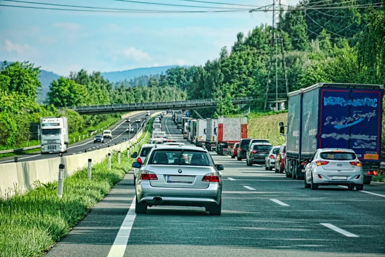 a highway filled with lots of traffic next to a forest, a photo, by Thomas Häfner, shutterstock, a ghetto in germany, breakdown, summer day, stock photo