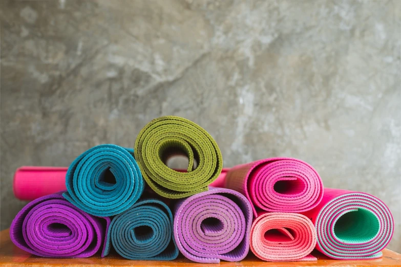 a pile of colorful yoga mats sitting on top of a wooden table, plasticien, iphone wallpaper, amazing background, chalk, on a gray background