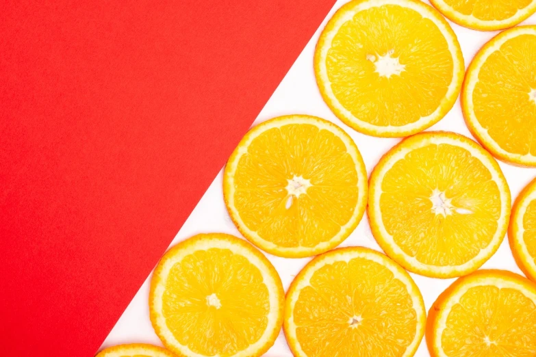 a close up of sliced oranges on a red and white background, by Anna Haifisch, trending on unsplash, postminimalism, 🦩🪐🐞👩🏻🦳, yellow and ornage color scheme, knolling, half image