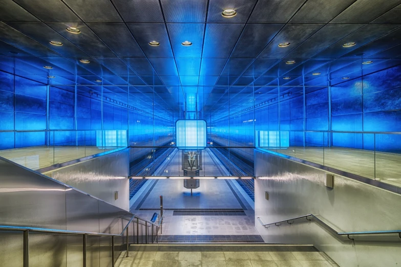 an escalator that is inside of a building, a picture, by Carl Rahl, flickr, light and space, silver and blue colors, subway station, tonemapping, blue reflections