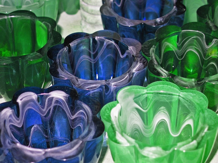 a group of glasses sitting on top of a table, by Doug Ohlson, flickr, chihuly, ruffles, green and blue color scheme, carved from sapphire stone