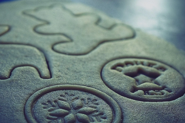 a close up of a cookie on a table, inspired by Rudolph F. Ingerle, flickr, concrete art, engraved vector, abstract claymation, sand, jungian symbols of winter