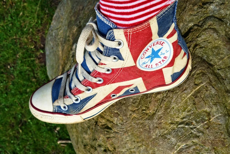 a close up of a person's shoes on a rock, a portrait, by Joe Bowler, pexels, union jack, converse, aged 13, !!highly detailed!!