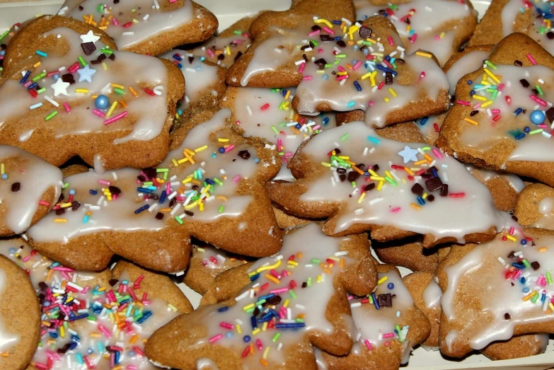 a plate of cookies with icing and sprinkles, a photo, by Ödön Márffy, wikimedia commons, seasonal, glazed, closeup photo