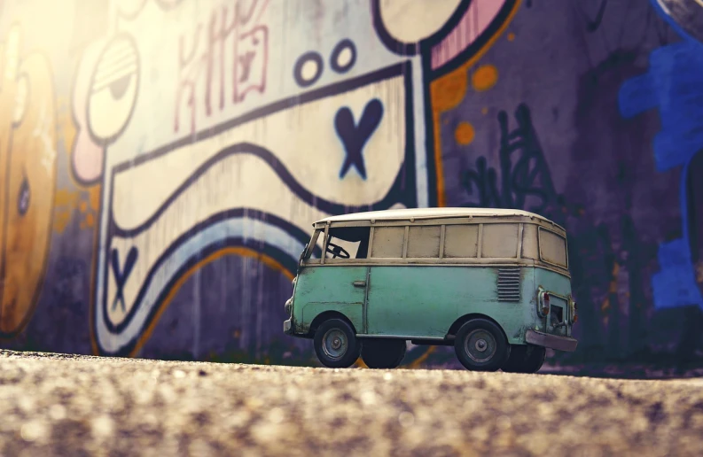 a toy van parked in front of a graffiti covered wall, a tilt shift photo, by Matthias Weischer, kombi, unreal engine. retro film still, octane render ”, journey