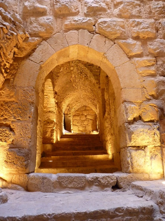 a tunnel in the middle of a stone building, by Saul Yaffie, romanesque, jerusalem, stone steps, warmly lit, in a gladiators arena landscape