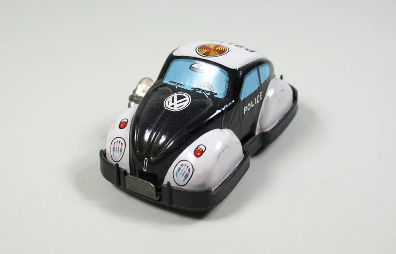 a close up of a toy car on a table, by Hans Schwarz, tumblr, retrofuturism, beetle, police, tokio aoyama, back