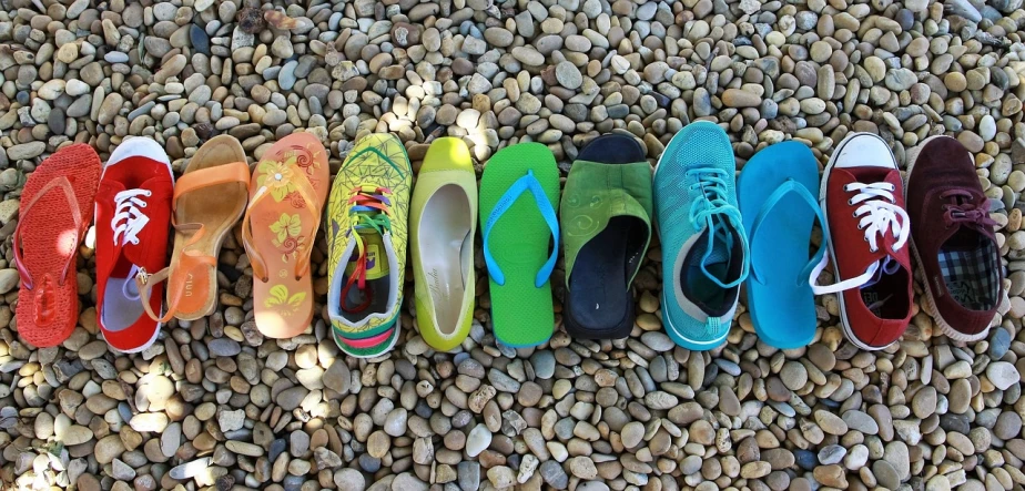a row of colorful shoes lined up next to each other, inspired by Jan Rustem, having fun in the sun, stones, green clothing, group photo