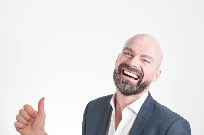 a bald man in a suit giving a thumbs up, a photo, inspired by Edi Rama, shutterstock, very attractive man with beard, laughing hysterically, close up portrait photo, pieter rudolph kleijn