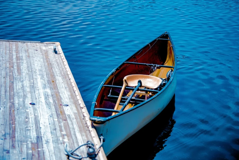 a boat sitting on top of a lake next to a dock, a picture, by Daniel Ljunggren, shutterstock, cinematic detail, canoe, rhode island, stock photo