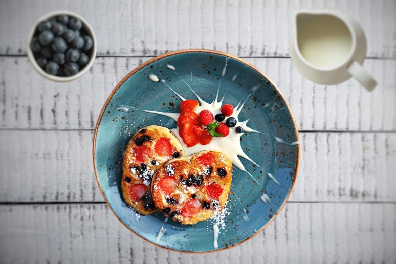 a close up of a plate of food on a table, a pastel, inspired by Richmond Barthé, pixabay, pop art, light red and deep blue mood, stroopwaffel, speckled, living food adorable pancake