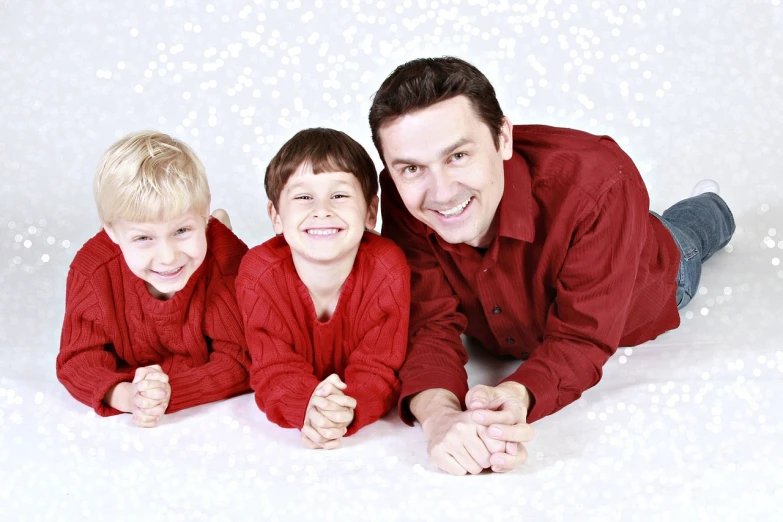 a man and two boys posing for a picture, pixabay, crimson clothes, glittering, laying on their back, husband wife and son