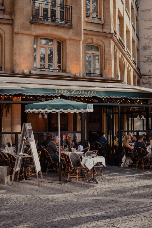 a group of people sitting at tables outside of a restaurant, a photo, by Raphaël Collin, pexels, art nouveau, awnings, features between french, 🦩🪐🐞👩🏻🦳, mamou - mani