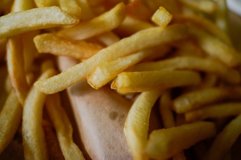 a hot dog covered in french fries on a bun, a picture, inspired by Pia Fries, pexels, photorealism, macro close up, ronald mcdonald, close up details, a wooden