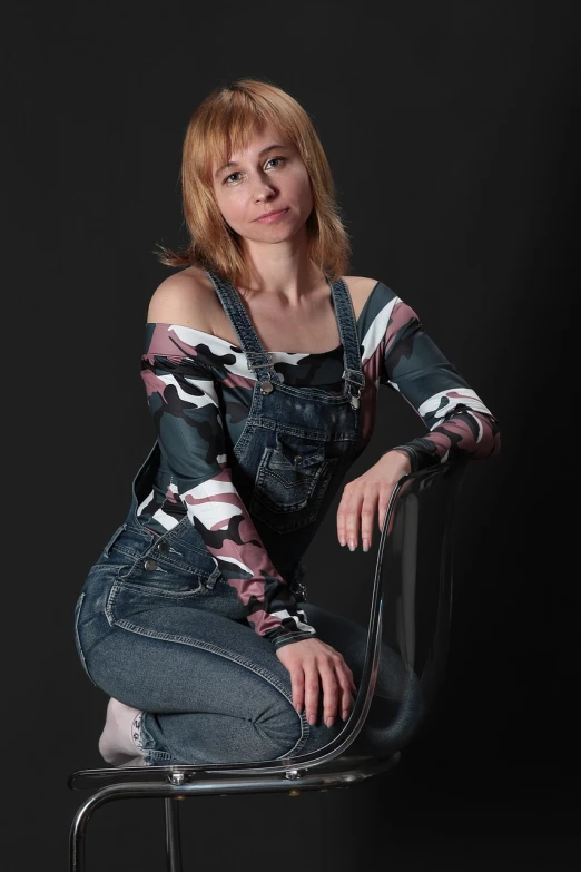 a beautiful young woman sitting on top of a chair, a portrait, flickr, figuration libre, overalls, she is about 40 years old, olya bossak, jeans and black boots