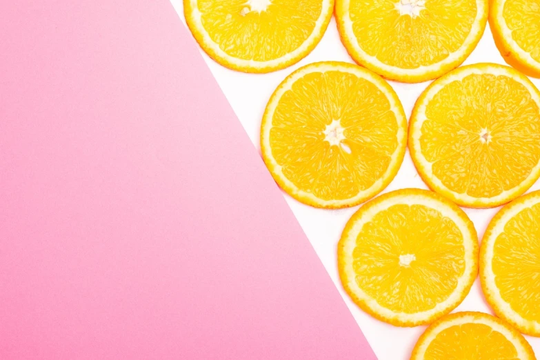 a close up of sliced oranges on a pink and white background, by Anna Haifisch, trending on unsplash, postminimalism, colors: yellow, 🐿🍸🍋, background image, 🍸🍋