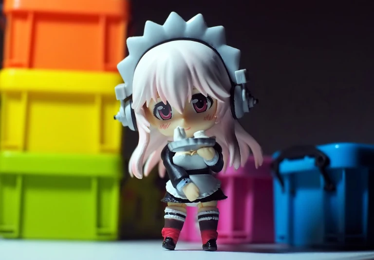 a close up of a toy figure on a table, pixiv, french maid, with head phones, spiky, shot with hasselblade camera
