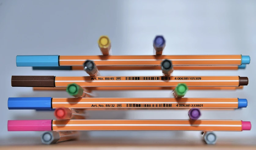 a group of pencils sitting on top of each other, by Werner Gutzeit, orange details, barcode, product display, prismacolor