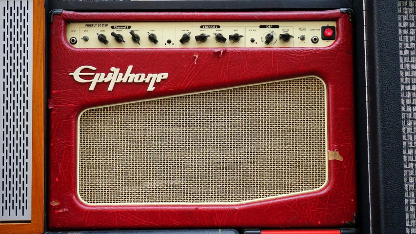 a red amp sitting on top of a wooden table, by HAP Grieshaber, euphoria, sharp nose with rounded edges, 'groovy', gritty textured