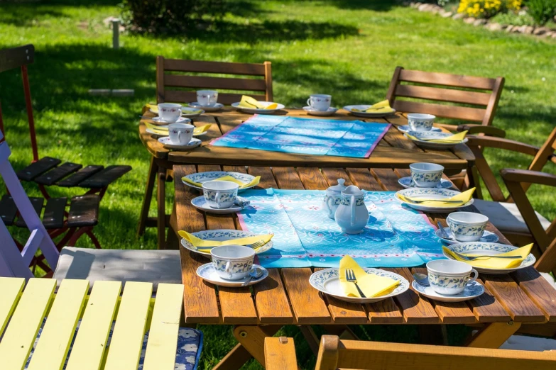 a table that has a bunch of plates on it, by Maksimilijan Vanka, shutterstock, naive art, bright sunny summer day, blue theme and yellow accents, high quality product image”, assam tea garden setting