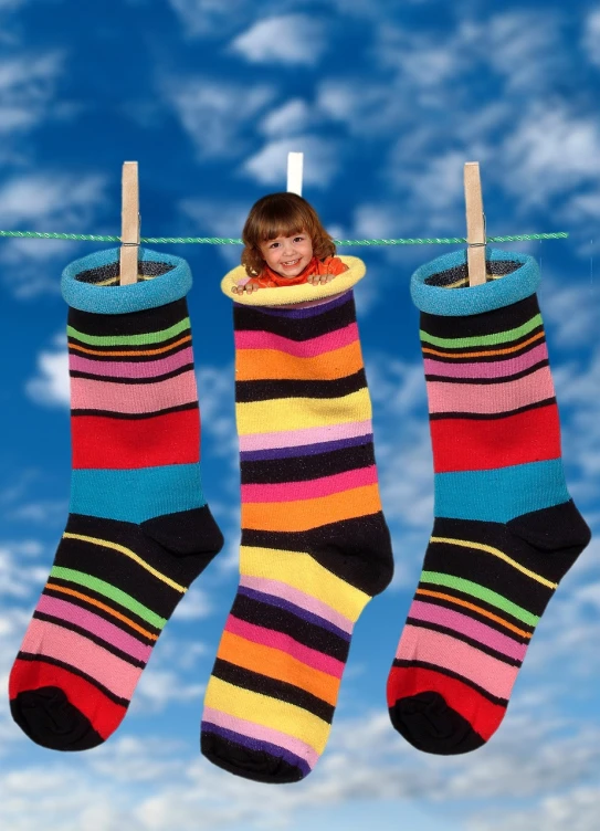 a little girl hanging out her socks on a clothes line, a photo, by Jan Rustem, flickr, naive art, istockphoto, stacked image, sky!, striped socks