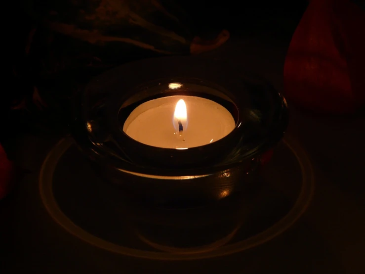 a lit candle in a glass bowl on a table, flickr, night photo, high res photo, unedited, phone photo