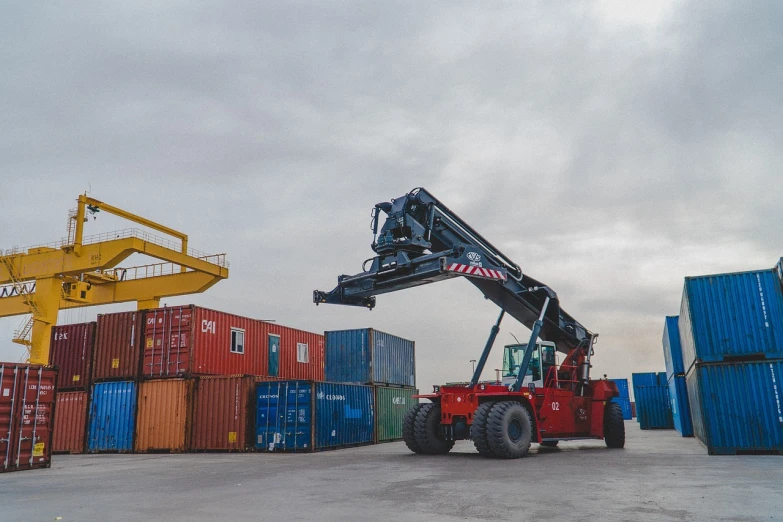 a crane is lifting a container onto a truck, by Richard Carline, pexels, amazing beauty, romanian, stock photo, a wide shot