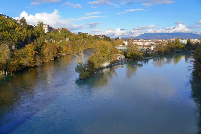 a large body of water surrounded by trees, a picture, by Karl Stauffer-Bern, shutterstock, urban view in the distance, november, highly detailed photo 4k, tarski fiume