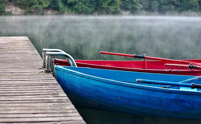 a couple of boats sitting on top of a wooden dock, a photo, by Ferenc Joachim, shutterstock, romanticism, green blue red colors, ((mist)), close up photograph, in a row