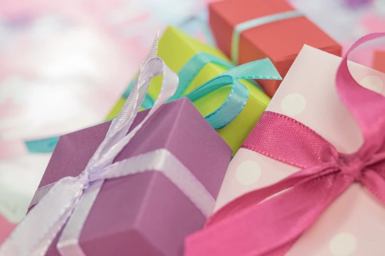 a pile of gift boxes sitting on top of a table, by Maksimilijan Vanka, pixabay, bright pastel colors, up close picture, straps, close up photo